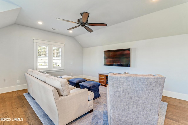 living area featuring baseboards, lofted ceiling, and wood finished floors