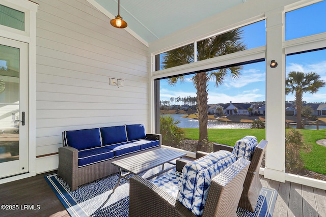 sunroom featuring lofted ceiling and a water view