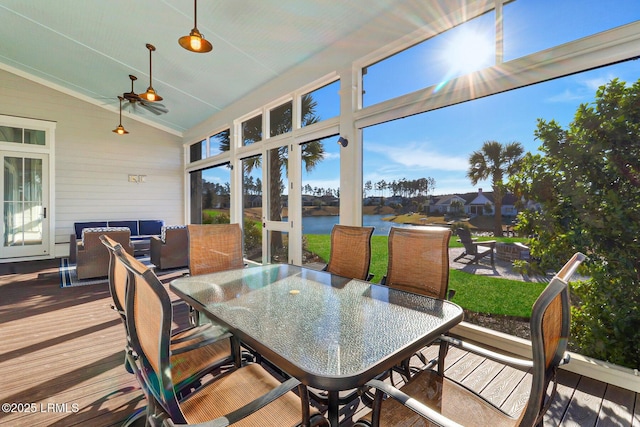 sunroom featuring lofted ceiling and a water view