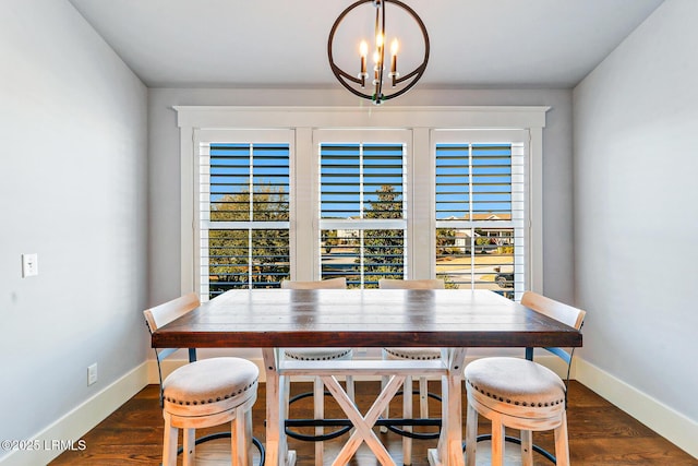 dining area with a wealth of natural light, dark wood finished floors, baseboards, and an inviting chandelier