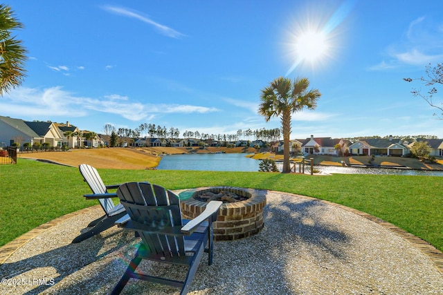 view of patio featuring a residential view, a water view, and an outdoor fire pit