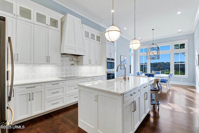 kitchen featuring premium range hood, a sink, tasteful backsplash, appliances with stainless steel finishes, and light countertops