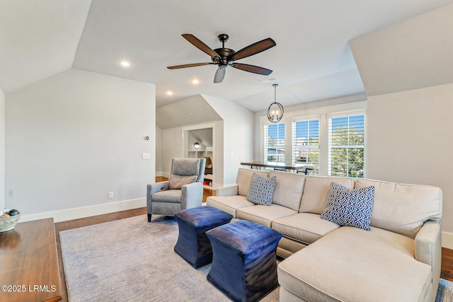 living room with ceiling fan, baseboards, lofted ceiling, and wood finished floors