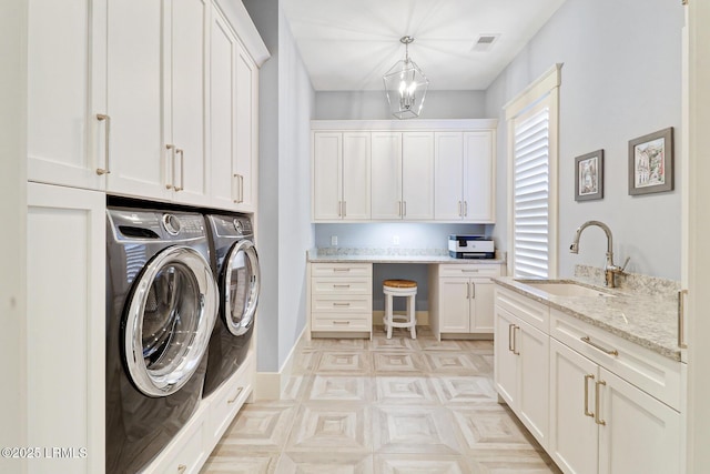 laundry area with visible vents, baseboards, washer and dryer, cabinet space, and a sink