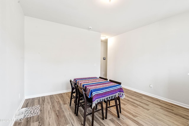 dining space with light wood-style flooring and baseboards