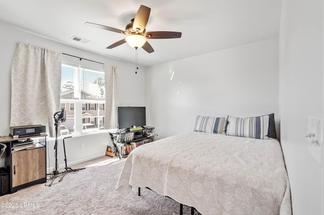 bedroom with a ceiling fan, light colored carpet, visible vents, and baseboards