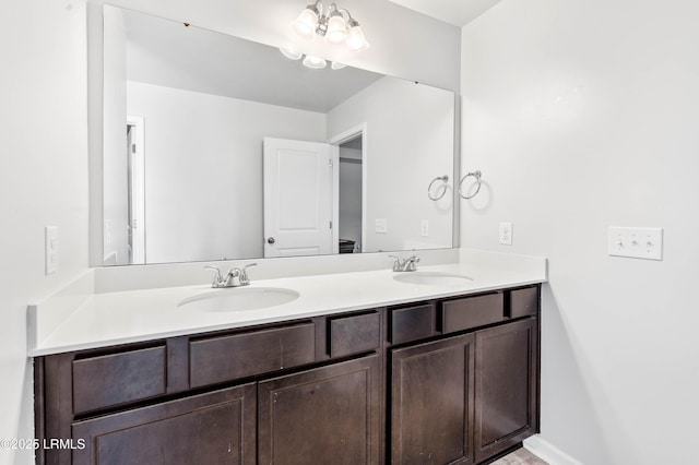 bathroom with double vanity, a sink, and baseboards