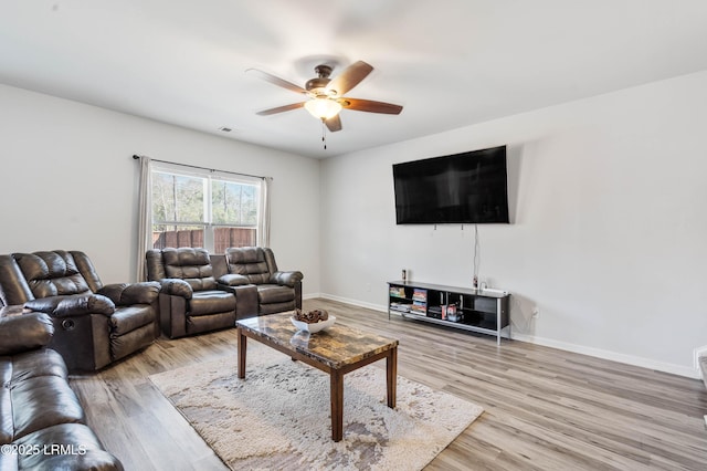 living area with light wood-style floors, visible vents, ceiling fan, and baseboards