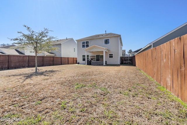 rear view of house featuring a fenced backyard