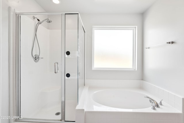 bathroom with a stall shower and a garden tub