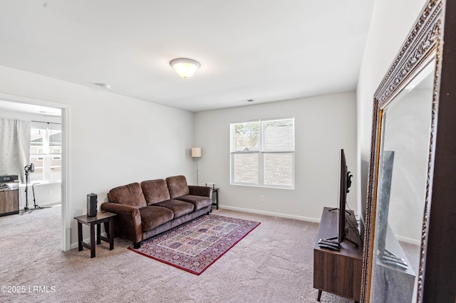 carpeted living area featuring baseboards