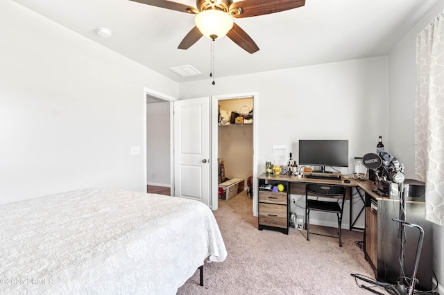 bedroom featuring a walk in closet, a closet, a ceiling fan, light carpet, and baseboards