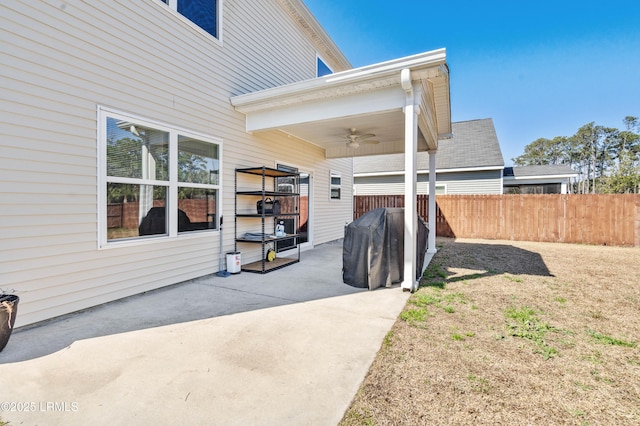 view of side of property with a patio area, fence, and a ceiling fan