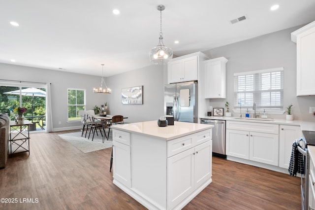 kitchen with recessed lighting, stainless steel appliances, wood finished floors, a sink, and visible vents