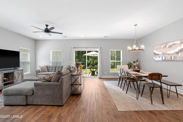 living area featuring ceiling fan with notable chandelier, recessed lighting, baseboards, and wood finished floors