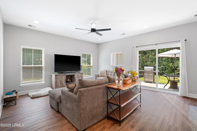 living room featuring baseboards, visible vents, wood finished floors, and recessed lighting