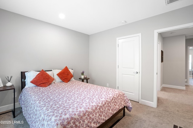 bedroom with light colored carpet and baseboards