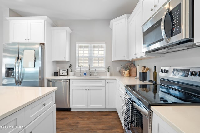 kitchen featuring light countertops, appliances with stainless steel finishes, a sink, and white cabinets