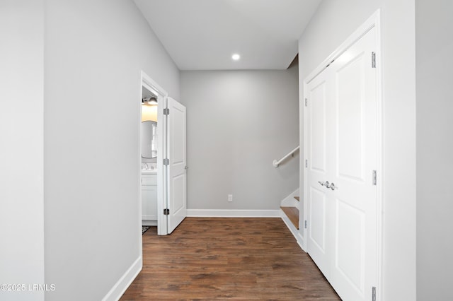 hallway featuring dark wood-type flooring, recessed lighting, stairway, and baseboards