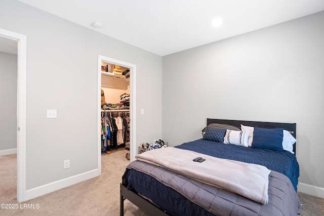 bedroom with carpet, a spacious closet, baseboards, and a closet