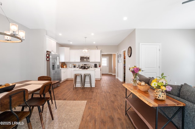 dining space with an inviting chandelier, baseboards, wood finished floors, and recessed lighting