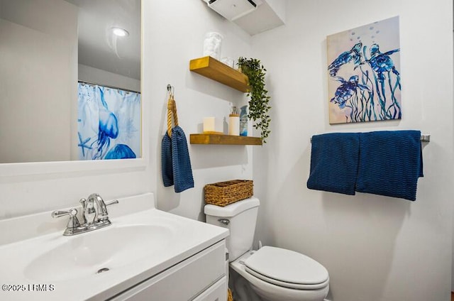 bathroom featuring a wall unit AC, toilet, and vanity