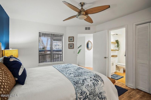 bedroom featuring ceiling fan, hardwood / wood-style flooring, ensuite bath, and a closet