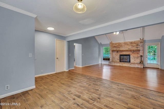 unfurnished living room with ornamental molding, a fireplace, light hardwood / wood-style floors, and vaulted ceiling