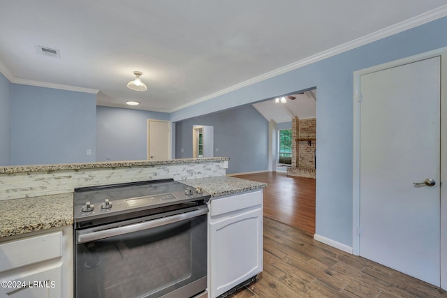 kitchen featuring stainless steel electric stove, white cabinetry, wood-type flooring, ornamental molding, and light stone counters