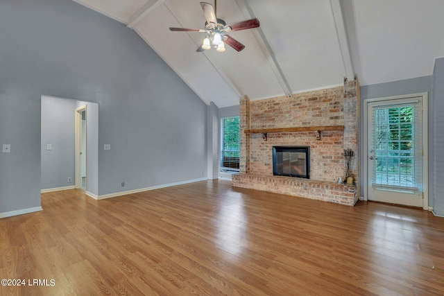 unfurnished living room featuring beamed ceiling, high vaulted ceiling, light wood-type flooring, and a fireplace