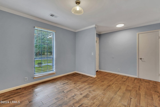 unfurnished room featuring ornamental molding and light hardwood / wood-style flooring