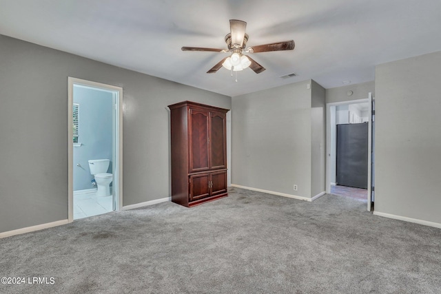 unfurnished bedroom with light carpet, connected bathroom, stainless steel fridge, and ceiling fan