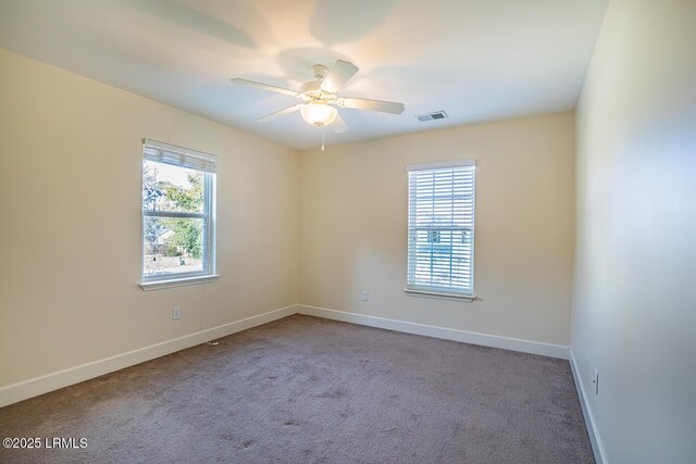 unfurnished room featuring carpet floors, a wealth of natural light, and ceiling fan