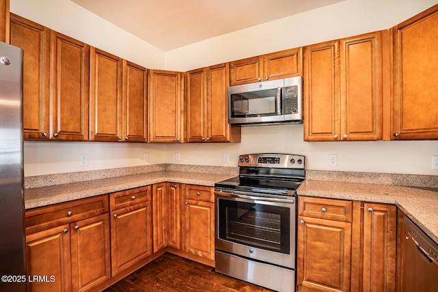 kitchen featuring dark wood-type flooring, stainless steel appliances, and light stone countertops