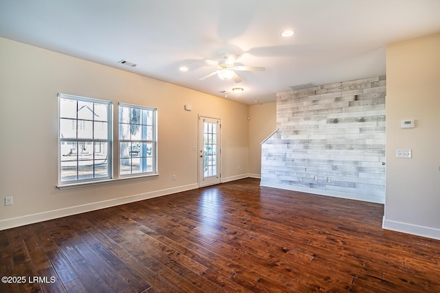 empty room with ceiling fan and dark hardwood / wood-style flooring