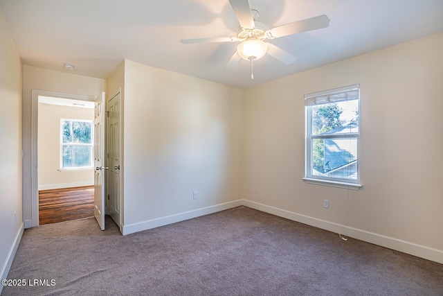 carpeted spare room featuring plenty of natural light and ceiling fan