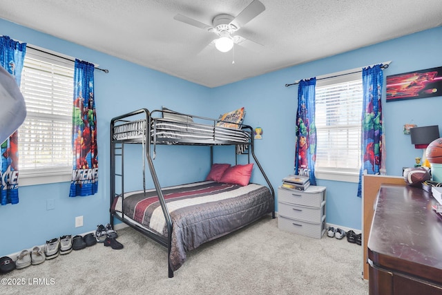 bedroom featuring ceiling fan, carpet flooring, and a textured ceiling