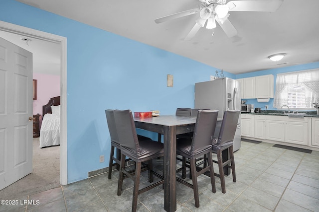 carpeted dining room featuring sink and ceiling fan