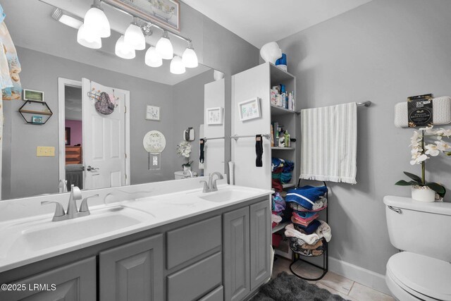 bathroom featuring vanity, tile patterned floors, and toilet