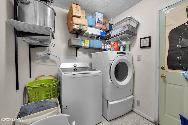 clothes washing area with washer and dryer and a textured ceiling