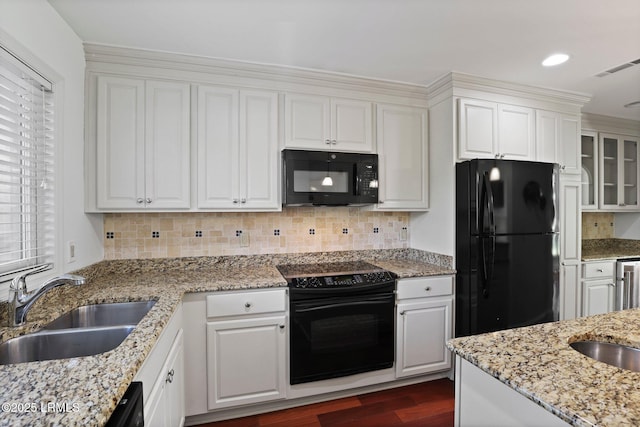kitchen with black appliances, a sink, dark wood-style floors, white cabinetry, and tasteful backsplash