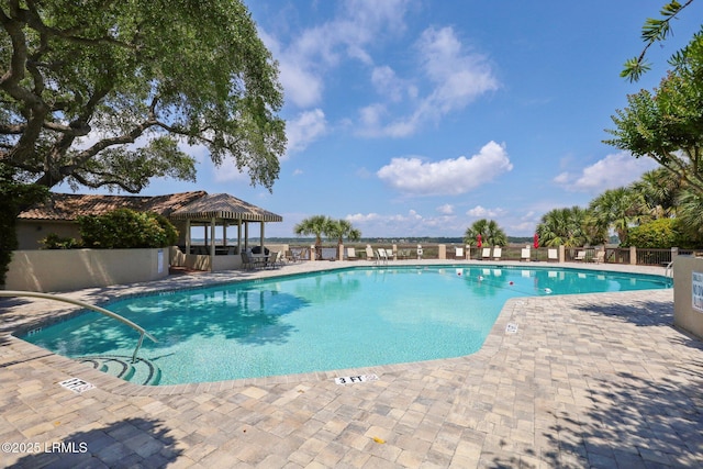 community pool featuring a gazebo, a patio area, and fence