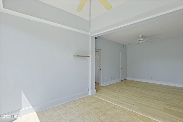 empty room featuring a ceiling fan, light wood-style flooring, and baseboards