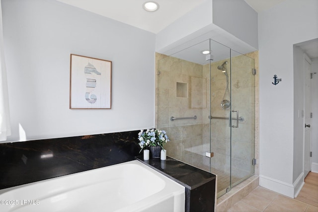 bathroom with a garden tub, a stall shower, baseboards, tile patterned floors, and recessed lighting