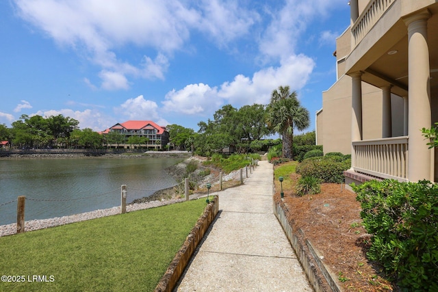 surrounding community featuring a water view and a lawn