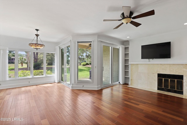 unfurnished living room featuring ceiling fan, a fireplace, crown molding, wood finished floors, and recessed lighting