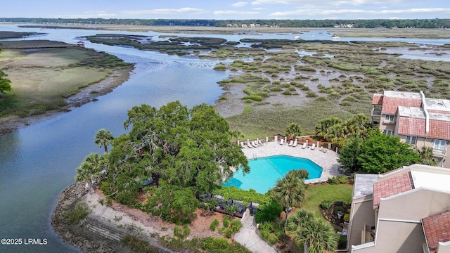 drone / aerial view of a pool area and a large body of water