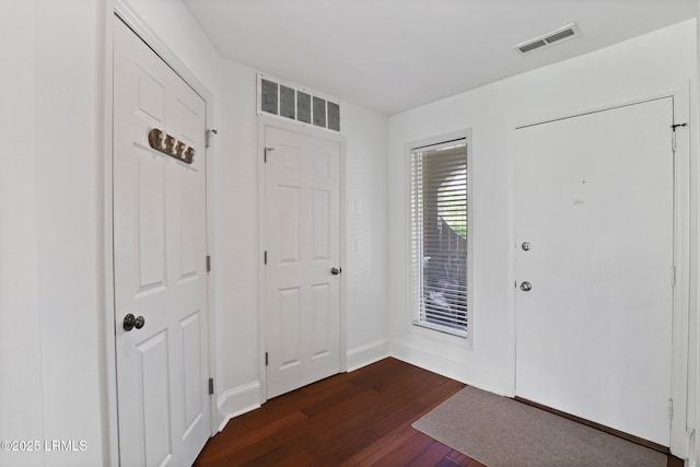 entryway with dark wood-type flooring and baseboards