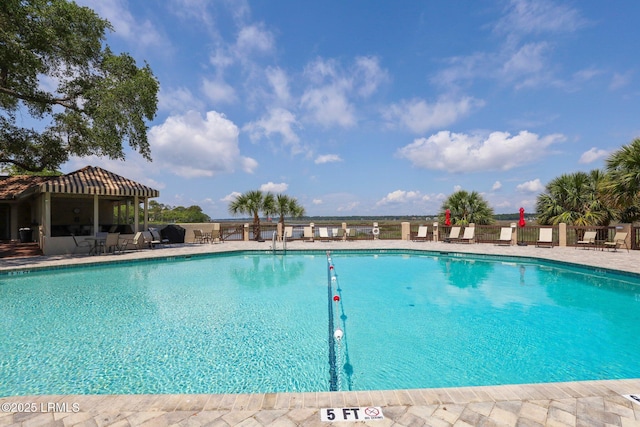 community pool with fence and a patio area