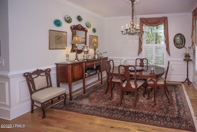 58 Wrights Point Cir, Beaufort, SC 29902 - dining space featuring a wainscoted wall, a decorative wall, wood finished floors, a chandelier, and crown molding